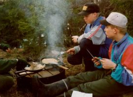 Svenske drenge laver mad over bål.
