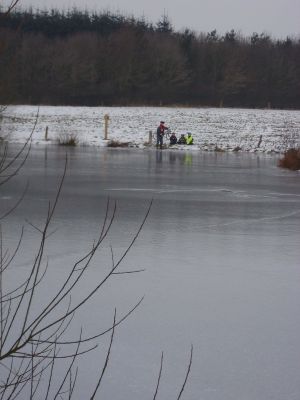 Skoleelever snakker med en fisker ved en sø