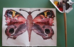 Mal en sommerfugl ved at folde våd farve.